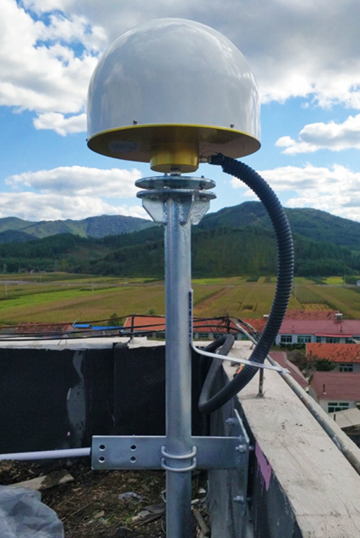 Kupolás GNSS-antenna kábellel, falra rögzített árbócon